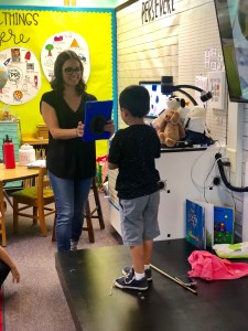 Teacher taking a photo of a student with an iPad