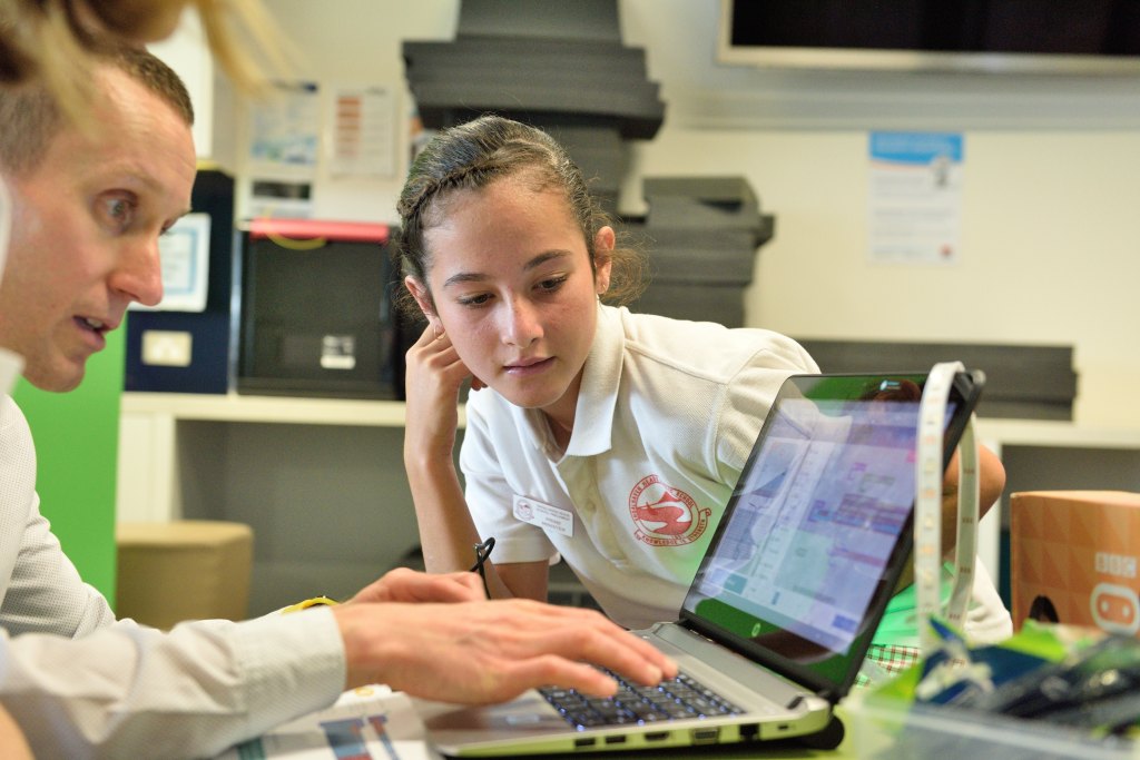 student leaning on table looking at laptop